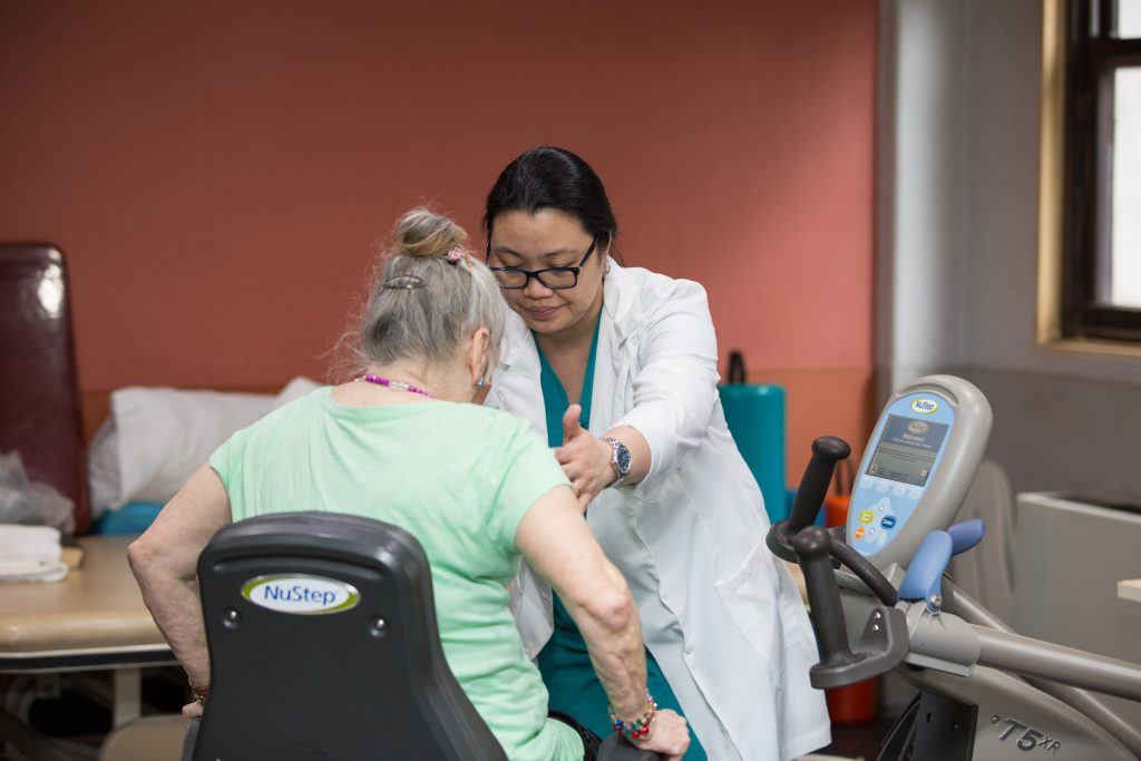 Therapist with patient Post-surgery rehabilitation for signs of neurological deterioration.