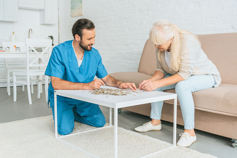 Memory Care social worker and senior woman holding puzzle pieces memory care nursing home queens nyc