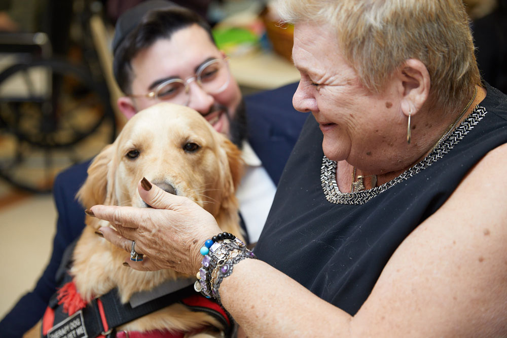 Elderly women playing with dog to combat loneliness