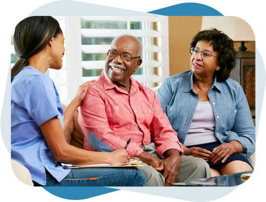 Nurse providing Alzheimers and dementia care to a senior black man sitting with his wife.