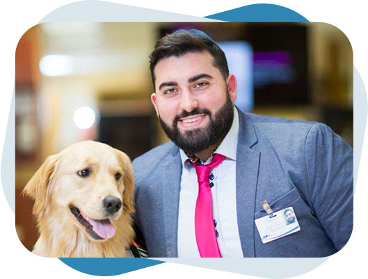 Pet therapy dog and therapist posing for a photo.