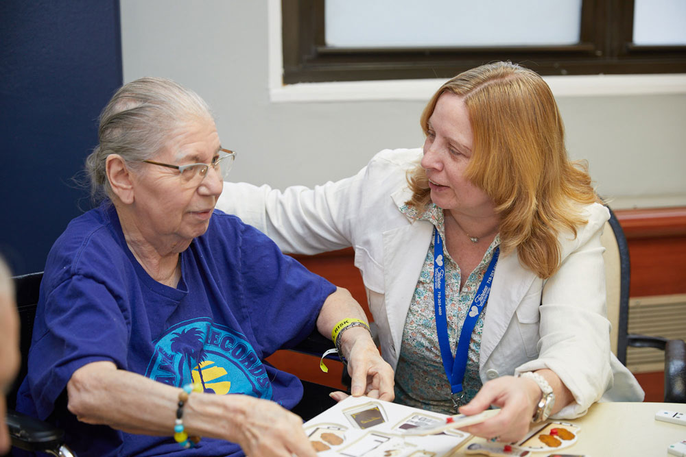 Fairview recreation worker helping elderly women to improve brain funstions