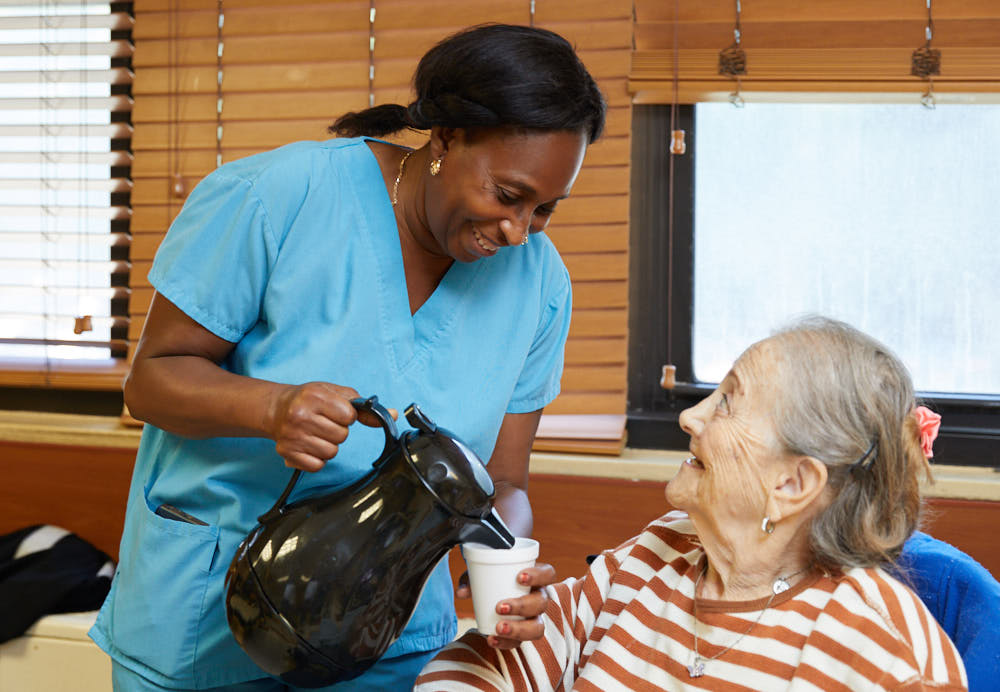 Fairview Rehab nursing staff giving coffee to an elderly resident and keeping track of it to help reduce caffeine intake