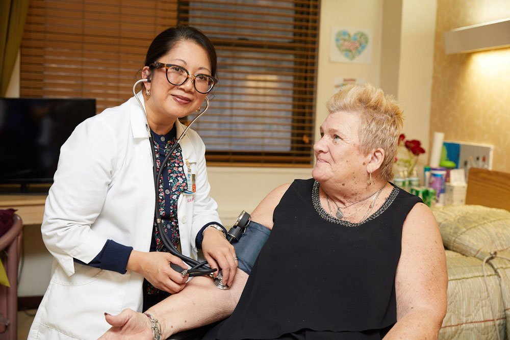 A nurse checking blood pressure of a patient at Fairview Rehab & Nursing Home