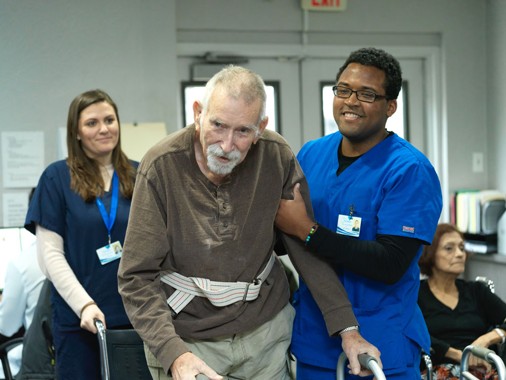 TBI Care Fairview experienced nursing staff providing TBI care and helping him to walk