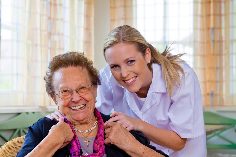 Nurse providing post surgery care to an elderly lade in a nursing home