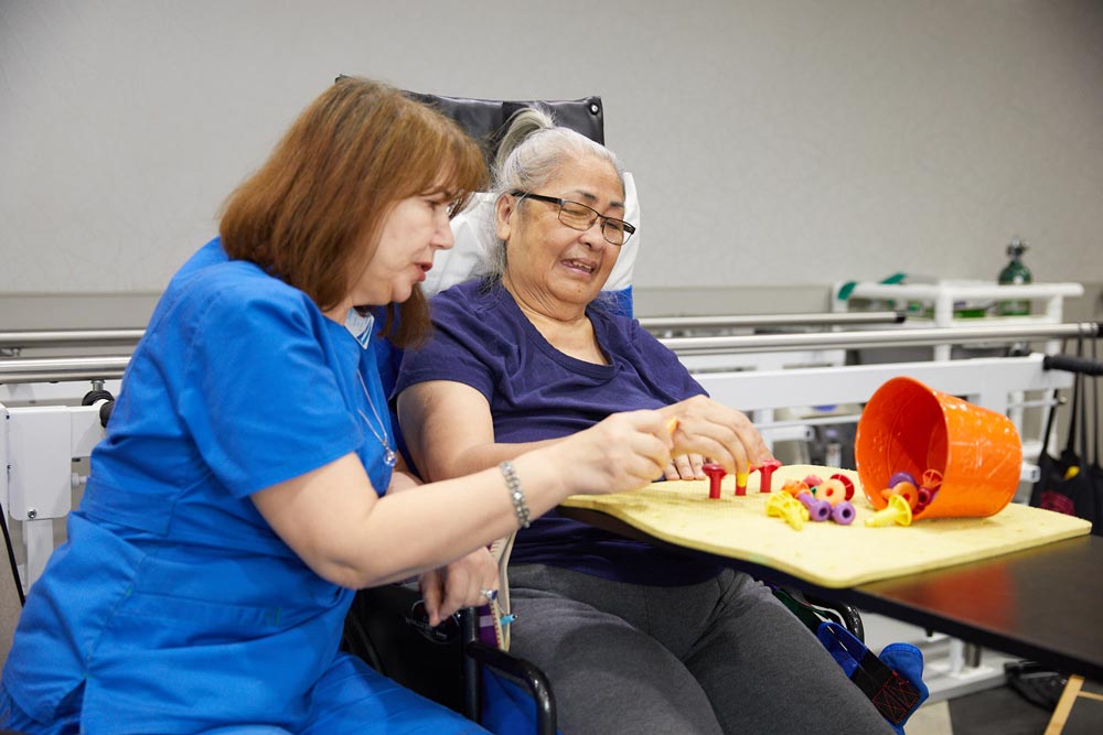 An elderly woman getting occupational therapy at Fairview Rehab