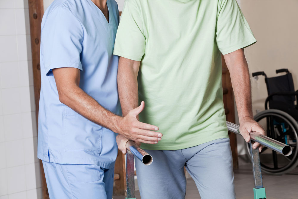 Nurse providing rehab therapies to an elderly man suffering from neurological diseases