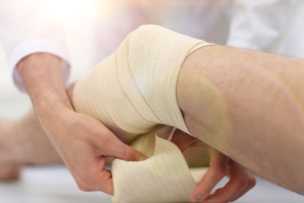 Doctor bandaging patients leg to speed up wound healing