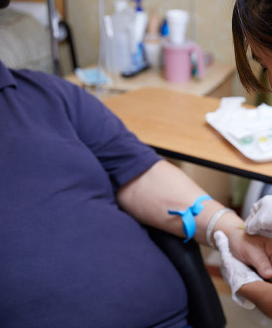 Nurse giving injection to patient suffering from open wounds