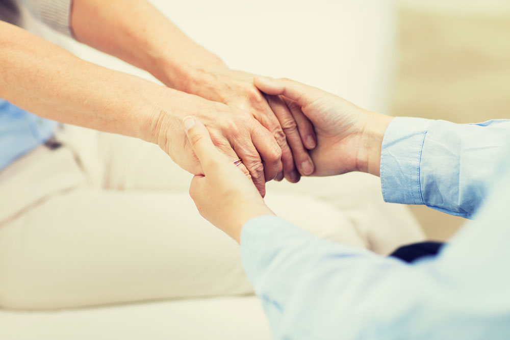 Substance abuse Nurse holding hands of a senior woman suffering from substance abuse conditions