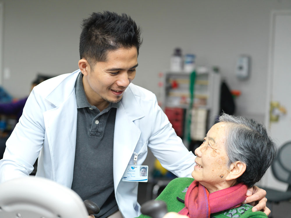 Male nurse providing wound treatment and care to an elderly woman