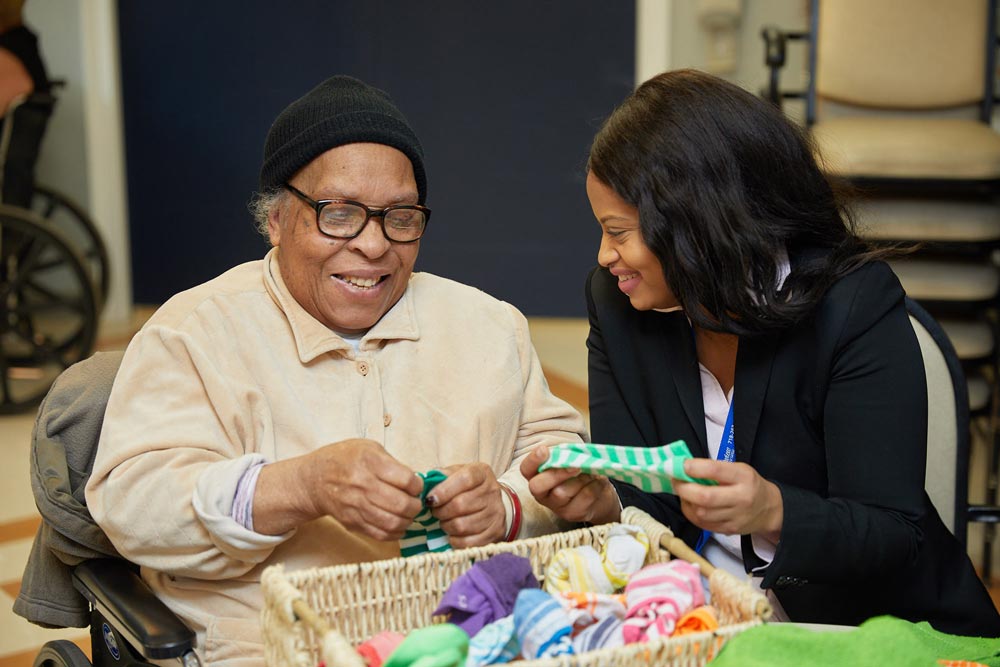 Elderly woman taking part in cognitive activities with nursing staff