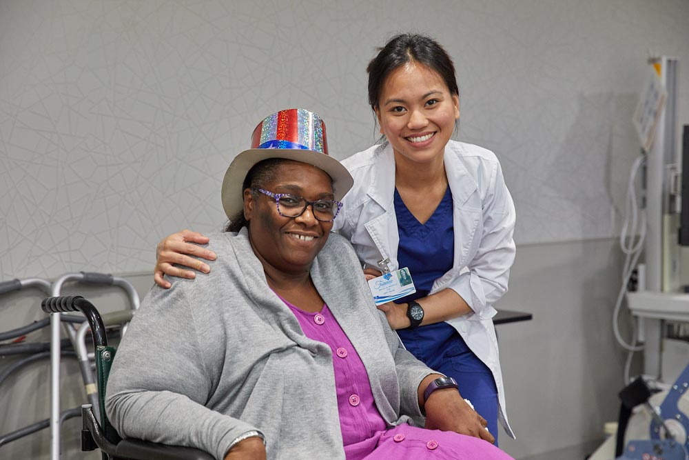 Elderly black woman smiling with rehab nurse after getting multiple sclerosis rehab