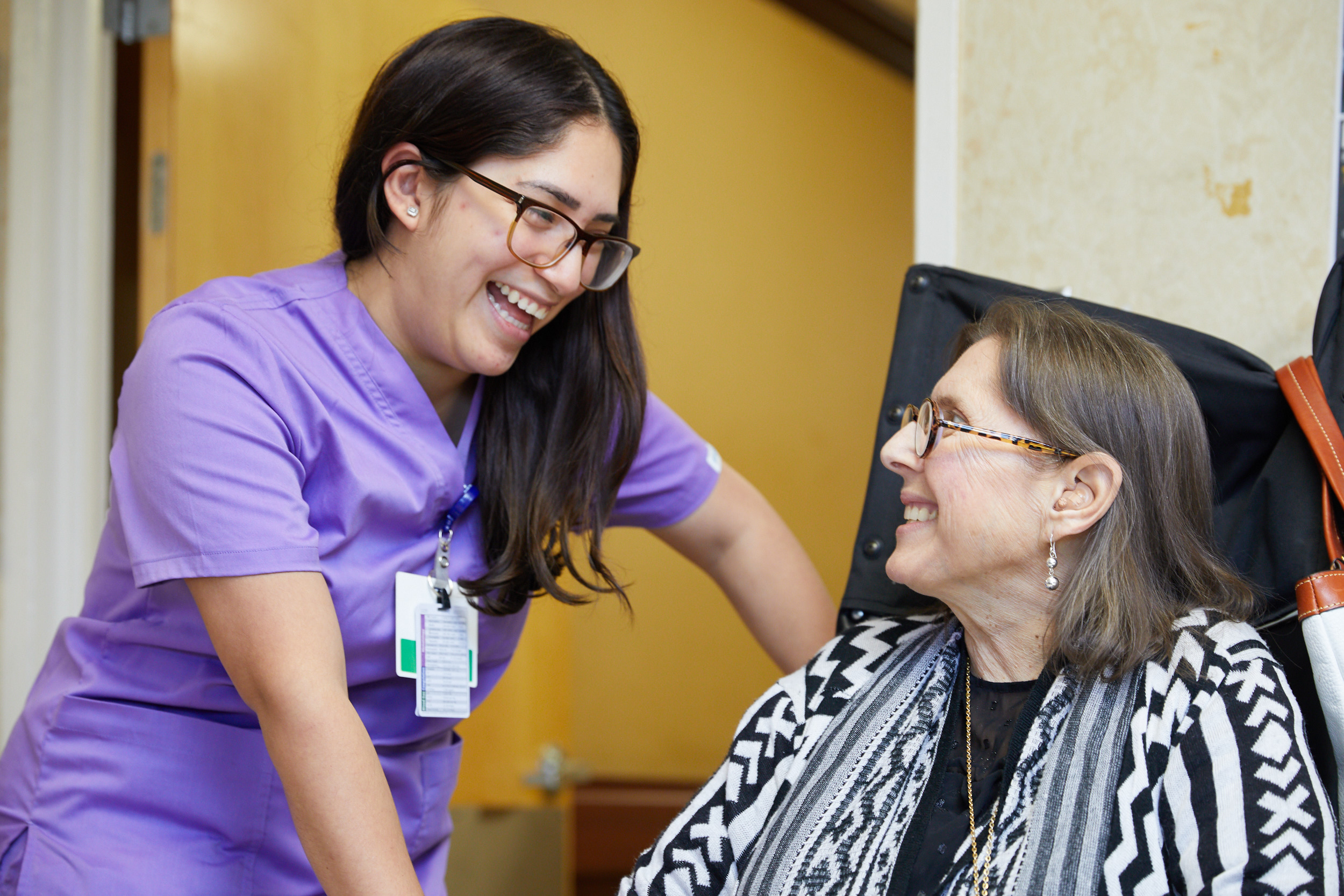 Smiling nurse chatting with senior woman as part of cardiac care to strengthen her weakened heart