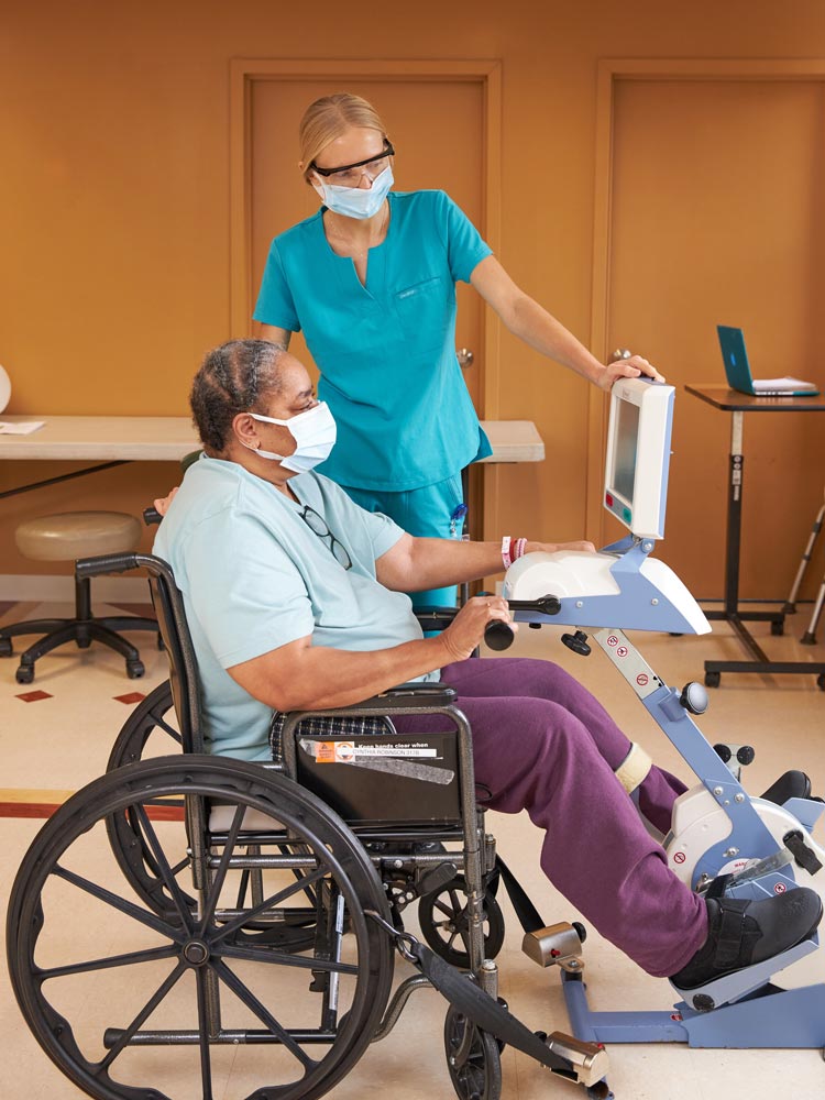 Nurse providing rehab to senior woman sitting on a wheel chair during cardiac care caused by congestive heart failure.