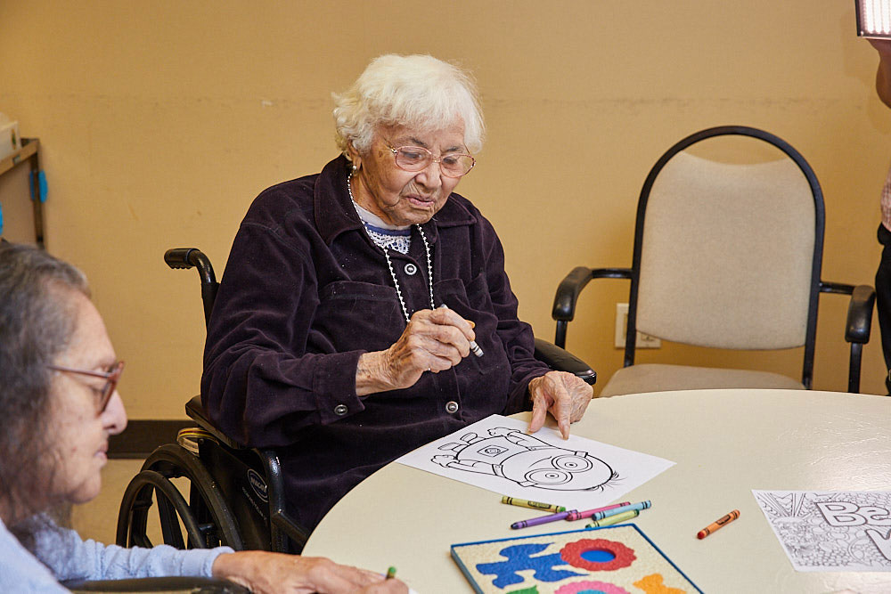 Senior woman filling colors on a sketchpad as part of brain exercises