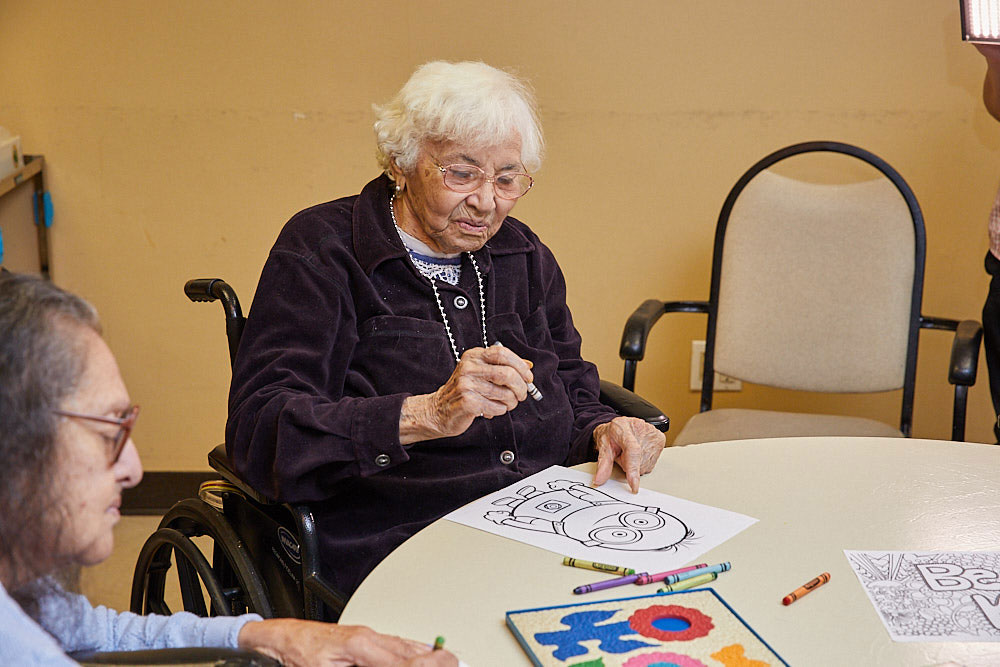 Brain Exercises Senior woman filling colors on a sketchpad as part of brain exercises