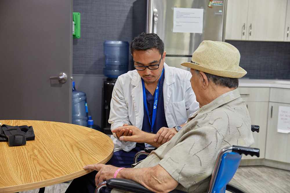 Doctor examining elderly patient for nerve injury.