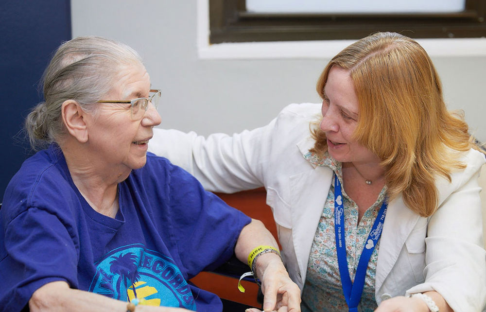 Therapist helping senior woman with speech therapy suffering from speech issues after stroke