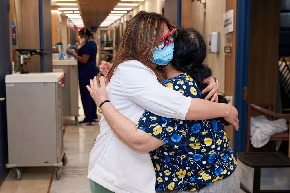 Nurse hugging elderly woman and providing emotional support to avoid emotional stress and anxiety to cause illness.