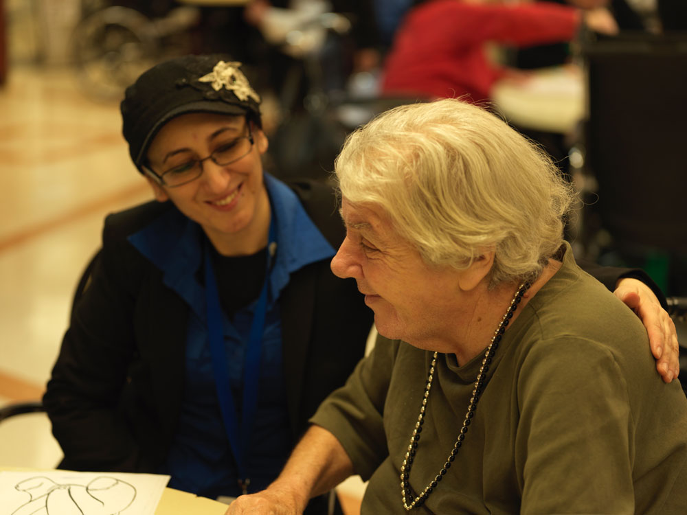 Smiling nurse and senior woman showing signs of mini stroke sitting together