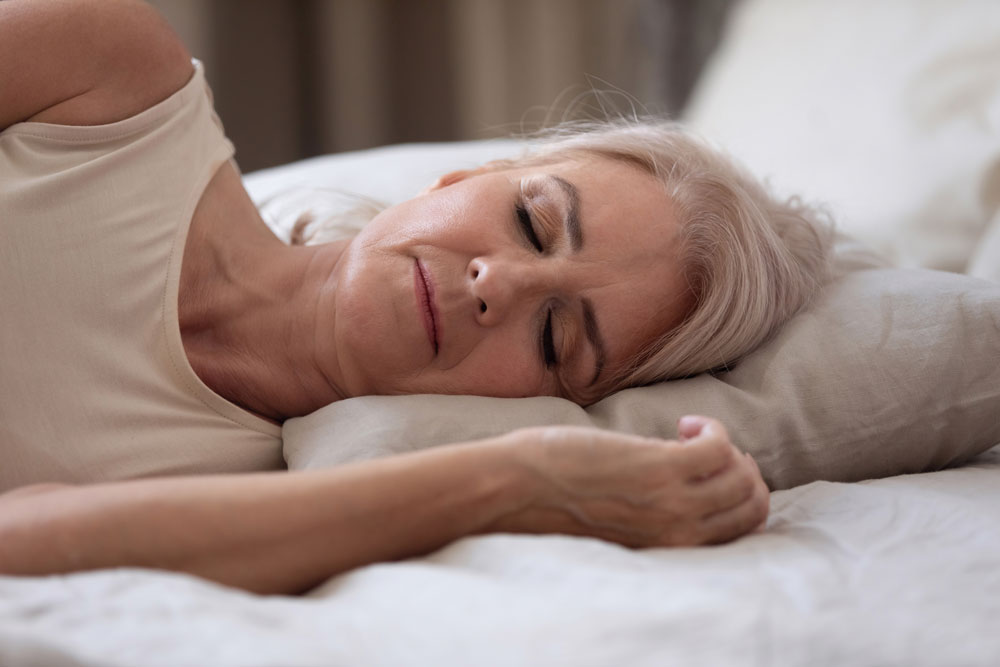 Elderly woman sleeping suffering from sleep apnea.
