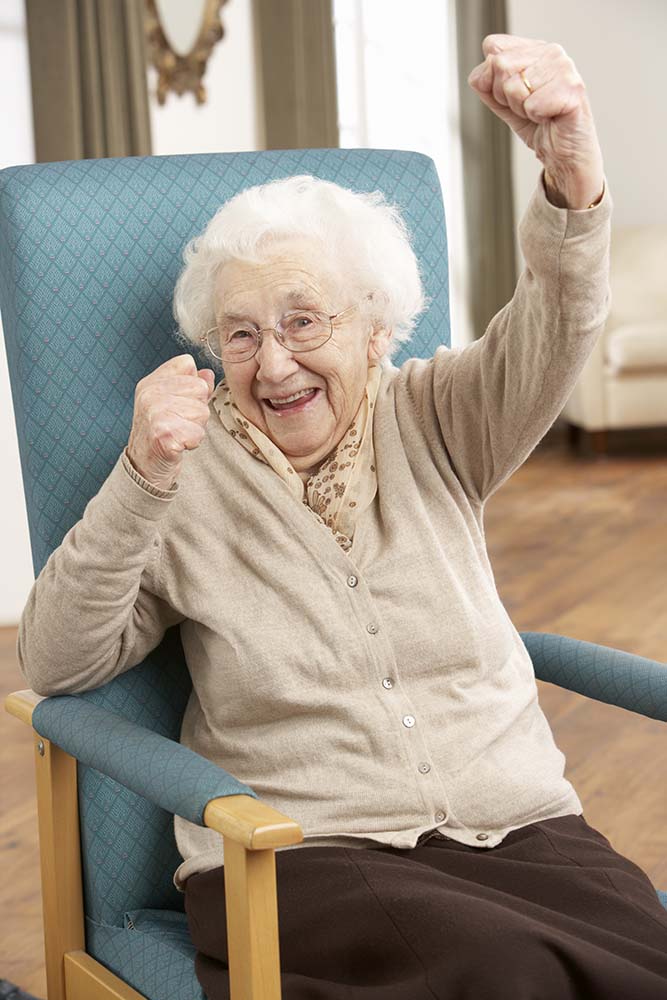 Senior woman doing chair aerobics to prevent permanent damage to broken shoulder.