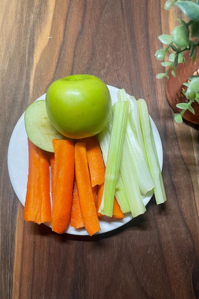Apple and carrots in a plate, best snacks for people with high cholesterol.