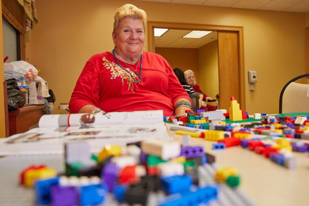 Senior woman enjoying while playing puzzles to reverse early signs of memory issues.