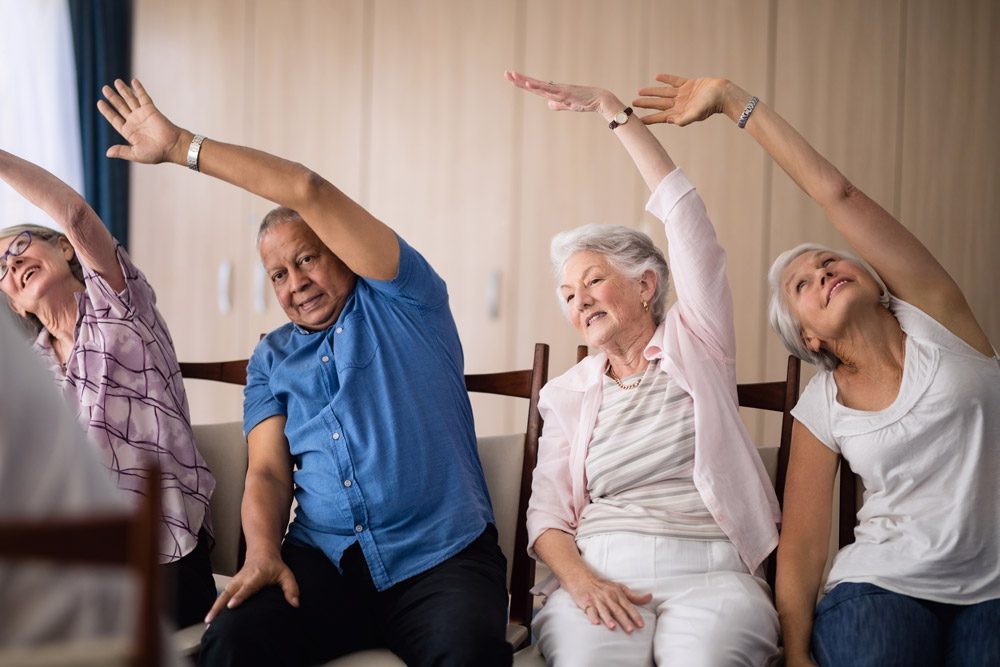 Senior people doing chair yoga to improve shoulder arthritis.
