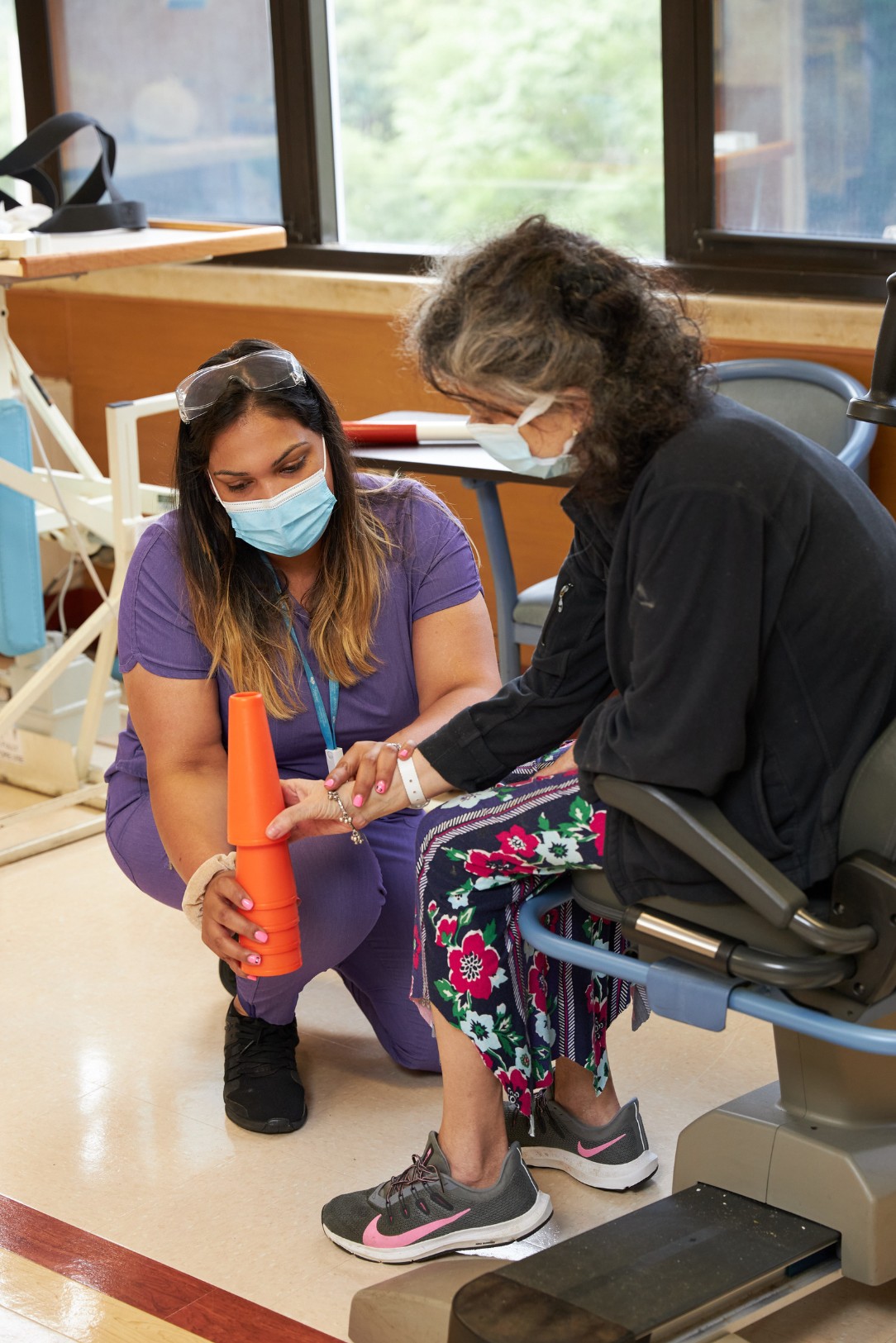 Physical therapist assisting a woman during rehabilitation, symbolizing support and treatment for widespread joint pain.