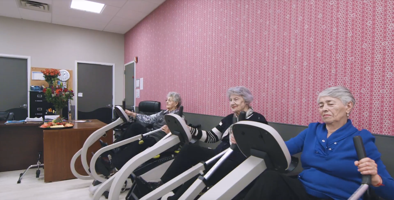 Poor Lymphatic Flow Elderly women exercising on stationary machines to improve circulation and reduce symptoms of poor lymphatic flow in a senior wellness center.