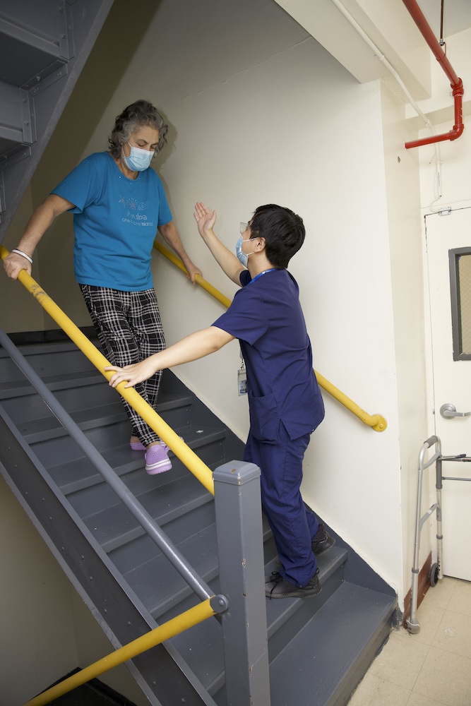 Improve your balance Therapist helping elderly woman getting down from stairs to improve your balance.
