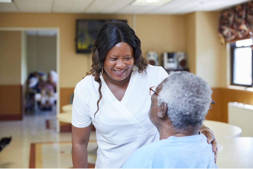 Caregiver providing Comfort Care to an elderly resident in a senior living community, offering compassionate support, reassurance, and personalized attention.